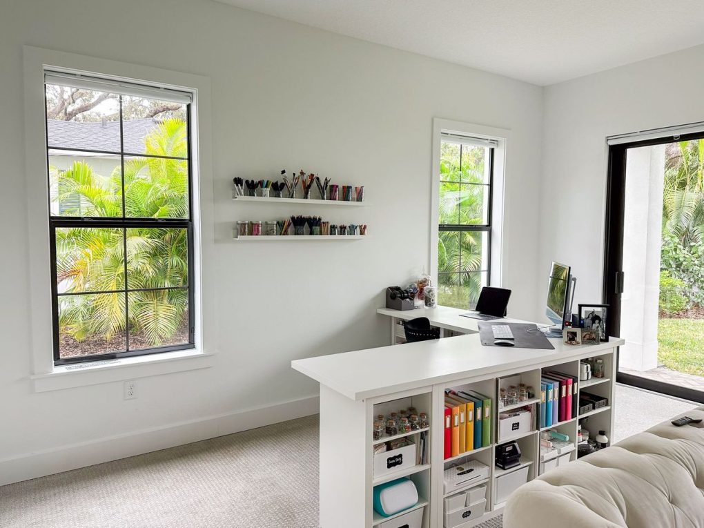 Organized creative studio with desk, colorful binders, and tools for digital scrapbooking & hybrid projects.