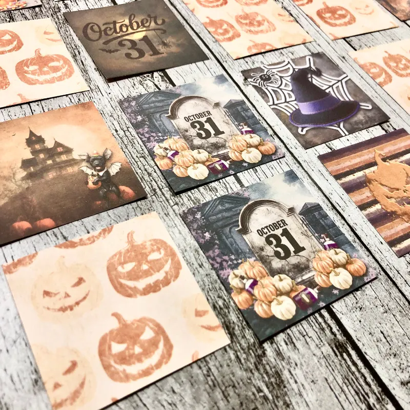 Hybrid scrapbooking project, Halloween-themed memory game cards, featuring pumpkins, haunted houses, tombstones with October 31, and other spooky imagery.
